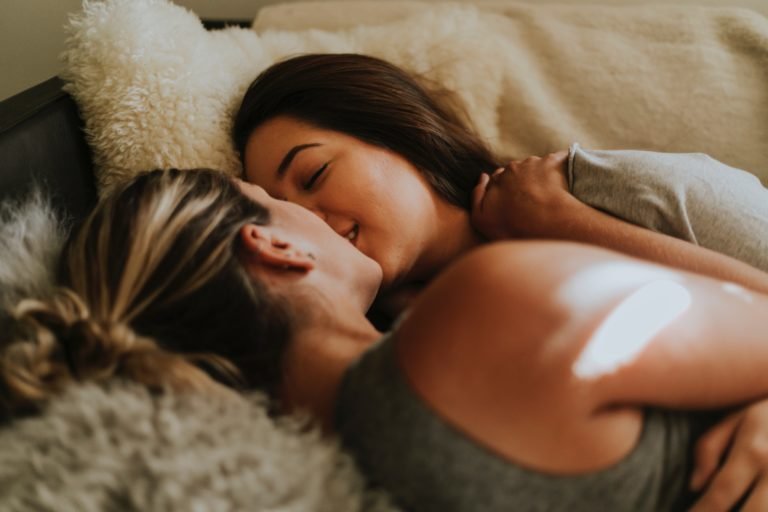 Twee vrouwen zoenen in bed