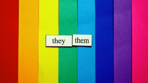 They/Them pronouns op een regenbooggekeurde papieren achtergrond.