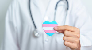 Arts die een hartje met de transgender vlag naar voren houdt.